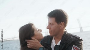 A man hugs a woman tightly and lovingly on the street on a sunny day.