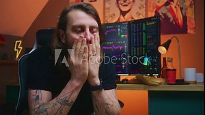 Depressed and shocked financial analyst turns around and thinks. Multi-monitor computer workstation with real-time stocks, exchange market charts. Man works in cryptocurrency trading at home office.