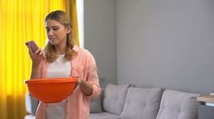 clip-1037181041-upset-woman-calling-roof-repair-service-while