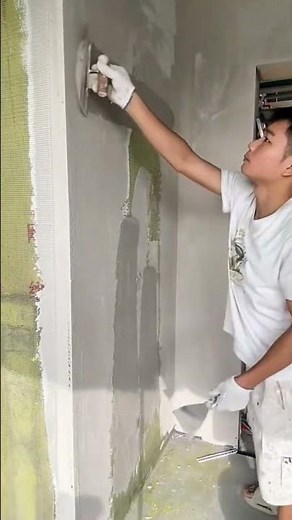 Expertly applying and smoothing cement render onto the wall surface carefully