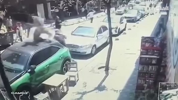 Shocking moment man tumbles onto car during earthquake and limps away
