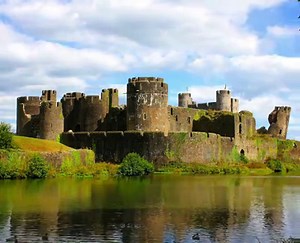Caerphilly Castle (Welsh: Castell Caerffili) is a medieval fortification in Caerphilly in South Wales. The castle was constructed by Gilbert de Clare in the 13th century as part of his campaign to conquer Glamorgan, and saw extensive fighting between Gilbert and his descendants and the native Welsh rulers. Surrounded by extensive artificial lakes – considered by historian Allen Brown to be "the most elaborate water defences in all Britain" – it occupies around 30 acres (12 ha) and is the second 