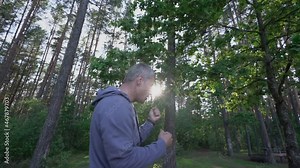 Male boxer hitting simulating punches at boxing in forest outdoors. Sport workout and training is hard.