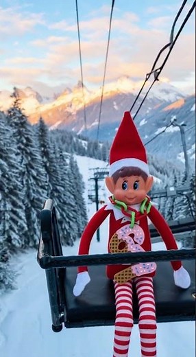 Make this elf sitting in a chairlift going up mountain. |...
