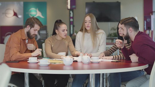 Students in a cafeteria discussing an assignment - Free Stock Video