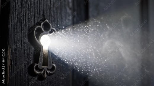 Bright light beam shining through a vintage keyhole on a dark wooden door. Swirling smoke and dust particles in the ray. Mystery, secret, and discovery concept