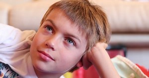 Closeup of handsome child face watching TV at home