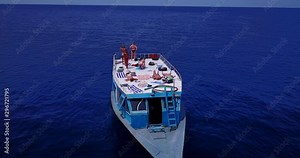 group of young attractive ladies sunbathing on the deck of the boat. Open ocean, aerial drone dolly out shot Stock Video