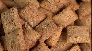 Crispy chocolate pads falling down slow motion. Cocoa cereal dessert for a fast breakfast. Morning breakfast dry chocolate pads close up. Chocolate flakes cereal pads with cream filling. FullHD