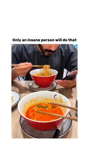 factogi on Instagram: "The post shares a 23-second video clip of a man at a restaurant using chopsticks to dip a white paper napkin into a bowl of red noodle soup and eating it, mistaking it for food amid the steam and dim lighting. Uploaded by @VolkaDio , an account focused on light-hearted memes, on 19 December 2025, it rapidly gained 2.2 million views and 5,470 likes, with replies joking about the napkin's unexpected 'chewiness' and texture. Such dining mishaps tap into viral trends of unscri
