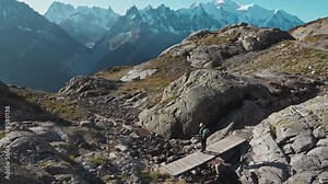 Hiker woman hiking on Lac Blanc with Mont Blanc massif among French Alps at France