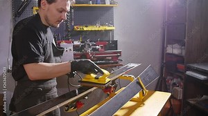Ski maintenance and repair concept. Workshop worker doing waxing and repairs ski and snowboard
