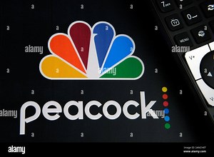 Peacock video streaming service logo on the paper brochure and the remote control next to it. By NBCUniversal, a subsidiary of Comcast Stock Photo - Alamy