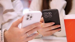 Two individuals engaged with their smartphones, demonstrating the role of technology and connectivity in daily life