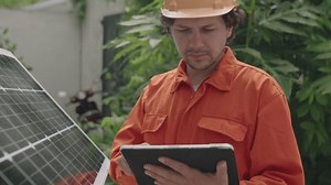 「屋外のソーラーパネルとデジタルタブレットを使用してワークウェアとハードハットにプロフェッショナルPVインストーラの中型ショット」の動画素材（ロイヤリティフリー）1103413783 | Shutterstock