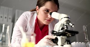 Student scientist looks through microscope in research laboratory. Science and education and chemical research
