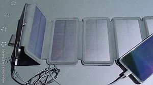 Charging a smartphone from home with a portable solar panel charger.Self-consumption and charging with small solar panels i