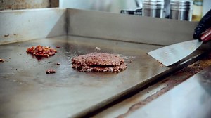 4k cinematic food cooking footage of a chef preparing and making a delicious homemade burger in a restaurant kitchen in slow motion by flipping the burgers Premium Stock Video Footage