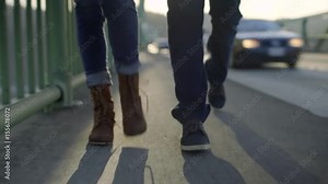 Closeup Of Couple's Feet As They Walk Together On Bridge, Next To Heavy Traffic