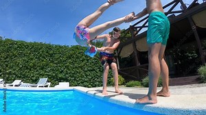Having fun group of children jumping and diving into swimming pool at pool party in summer sunny day. Happy children. Slow motion. Childhood, friendship, vacation concept