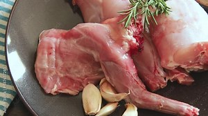 raw rabbit meat with spices and herbs on plate