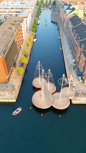 Architecture & Design on Instagram: "The Circle Bridge is a pedestrian and bicycle bridge located in the heart of Copenhagen, Denmark. Designed by @StudioOlafurEliasson, the bridge spans across the Christianshavn Canal and connects the two districts of Christianshavn and Holmen. The bridge takes its name from its circular shape, which gives it a unique and eye-catching appearance. It is made of steel and has a diameter of 40 meters, with a broad deck that provides ample space for pedestrians and
