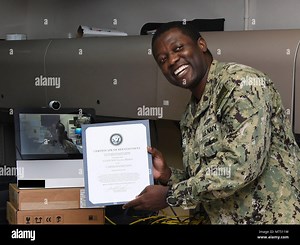 170727-N-XP344-015 MANAMA, Bahrain (July 27, 2017) Information Systems Technician 2nd Class Lucian Matthias, assigned to U.S. Naval Forces Central Command, poses for a photo after having been administered the oath of enlistment by his brother Army Maj. Leon H. Matthias Jr., assigned to 532nd Military Intelligence Battalion, 501st Military Intelligence Brigade in Camp Humphreys, South Korea, on screen, via a video teleconference. (U.S. Navy photo by Mass Communication Specialist 2nd Class Victori