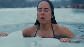Woman doing winter swimming. Submerging herself in the ice cold water...