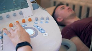 A man is undergoing ultrasound procedure performed on a sonic console