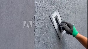 Applying decorative plaster with marble chips to the wall of the house. The hand of the builder professionally applies the final layer of the building mixture. Horizontal Promotional Video.