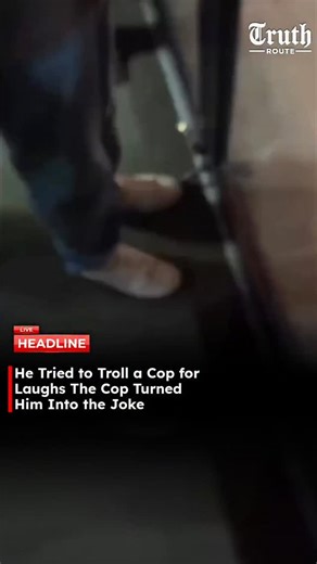 Truth Route News on Instagram: "A video shows a man standing outside a police office, separated by a glass window. The man begins provoking the police officer by sticking out his tongue and pretending to take photos from outside. Instead of showing a real picture, he flashes a clown image on his phone screen toward the officer. The police officer responds instantly by activating a bright flash from inside, turning the moment back on the man. The prank attempt fails, and the situation quickly fli