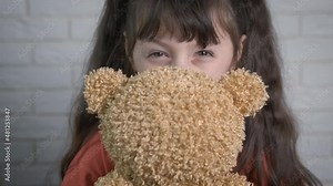 Enjoying time with teddy bear. A playful little girl enjoy the time with teddy bear in the room.