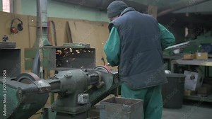 Sword being sanded and sharpened at modern swordsmith's workshop.