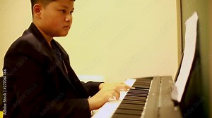 Cute kid playing piano, Asian cute boy playing piano in music room. Professional boy play piano. There are musical instrument for concert or learning music. Stock Video