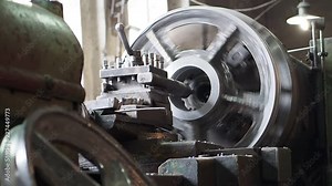The machine processes a detail. Production at machine-building enterprise. Working process. Metal working and production at the plant. Big detail in the foreground.