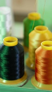 Download Bright threads in spools for tailor. Colorful spools with threads for sewing industry. Different colors of threads on the table. Handicraft. Vertical for free