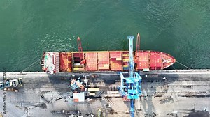containers, cargo ships and loading cranes in port