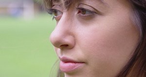 Extreme Close Up - A young woman looks into the distance with a straight face - shot on RED