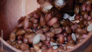 Professional nut roaster machine for mixing, roasting and glazing peanuts: close up, slow motion. Production, manufacturing, preparation, technology and street food concept