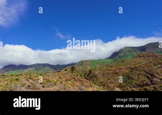 Timelapse of fast moving orographic clouds flowing over a mountain ridge and descending into the valley. Dramatic cloud movement creates a natural scene with dynamic sky and atmospheric landscape Stock Video Footage - Alamy