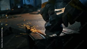 Assembling metal structures, making a self-made body armor plate by a professional worker using a grinding machine. Grinding work with smooth equipment for steel metal, iron, sparks in a heavy