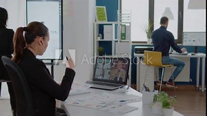 Businesswoman using video call for business meeting with colleagues on computer screen. Corporate employee talking to workmates on remote online conference for marketing project.