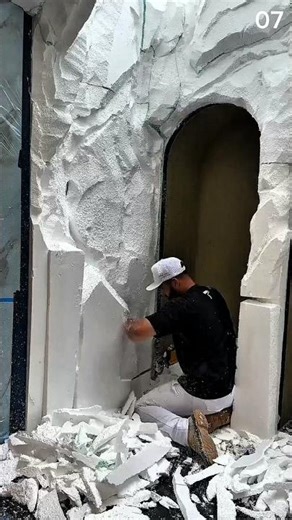 The process of shaping styrofoam to create wall texture before the finishing stage.