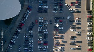 Top view zoom out car driving on parking place. Aerial view from above flying drone car moving and standing on parking lot in modern city. Car traffic and parking concept.High quality 4k footage