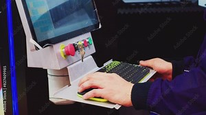 Modern industry. A man at work at a machine control panel. An operator controls industrial equipment using a computer. Close-up.