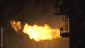 Well testing operation (flaring) of an oil and gas drilling rig. Burning huge gas flame controlled by the deluge system