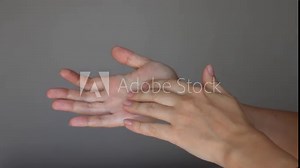 The problem of hyperteriosis. Young woman touching her sweaty palms on a grey background. Сlose-up of clammy female hands. Hyperhidrosis, Increased sweating of the hands