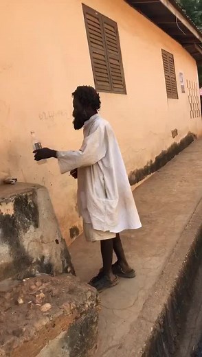 Adult Male Lighting Cigarette Outside Building