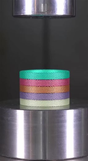 Nic Davis on Instagram: "Watch as a tall stack of translucent prism-fiber composite tokens gets crushed by a hydraulic press. The layered structure buckles and delaminates beautifully, with rims flattening and a faint clear resin bead appearing at the base in this ultra-satisfying ASMR moment."
