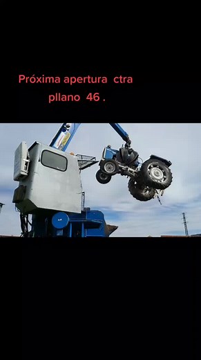 Blue Tractor Dismantled by Crane in Scrapyard Setting